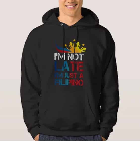 A man wearing a hoodie with the text "I am not late, I am Filipino"