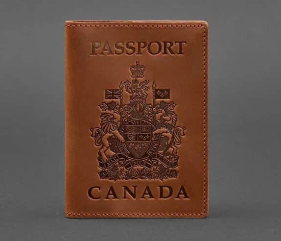 A brown leather passport cover with a Canada print