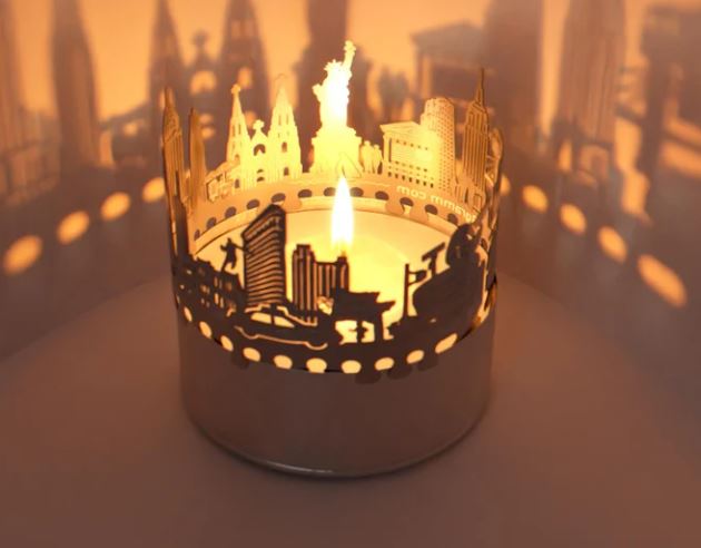 A tea candle light holder with teh shapes of New York City skyline