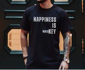 A man wearing a black shirt with "Happiness is whiskey"