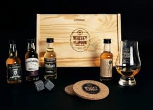A wooden box with four small bottles of whiskey