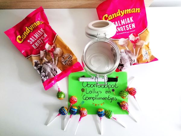 A photo of packages of lollipops, a jar and a note