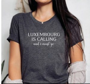 A woman wearing a shirt with "Luxembourg is calling and I must go"