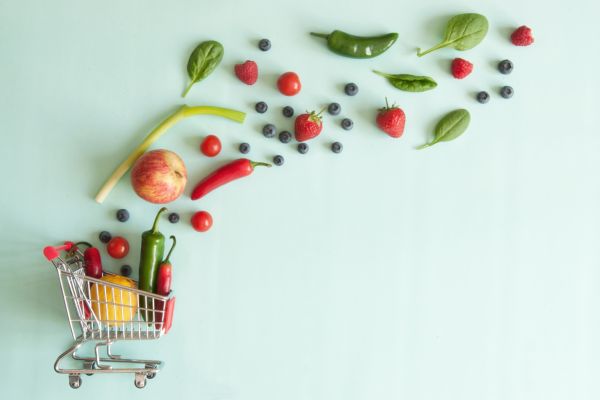 An image of a small grocery cart with veggies